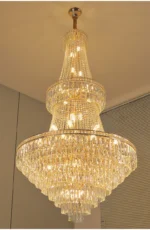 Modern crystal chandelier for dining room hanging over a wooden table with warm glow
