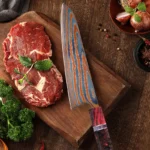 8-inch Damascus chef knife with titanium timascus blade and stabilized colored wood handle on cutting board