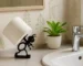 White 3D printed ant toilet paper holder on a bathroom vanity with marble countertop and a small plant.
