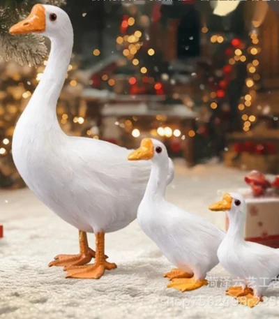 Realistic white goose statue on a garden lawn with green grass background