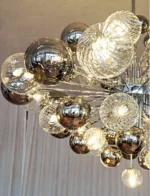 Smoky gray chandelier with glass bubbles hanging over a modern dining table