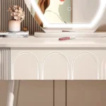 Modern wood makeup vanity table with mirror, drawer, and stool in a bedroom setting
