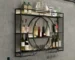 Black wall mounted wine rack with wine bottles and glasses on display