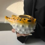 Creative pufferfish tiki mug for cocktails with vibrant hand-painted details on a wooden table