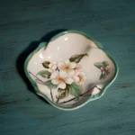 Ceramic divided bottle for toothbrushes, floral pattern, on modern bathroom vanity.