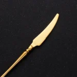 Matte gold flatware set with antique finish arranged on a wooden table