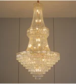 Modern crystal chandelier for dining room hanging over a wooden table with warm glow