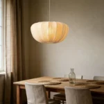 Wabi sabi pendant light hanging over a wooden dining table in a cozy room