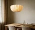 Wabi sabi pendant light hanging over a wooden dining table in a cozy room