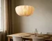 Wabi sabi pendant light hanging over a wooden dining table in a cozy room