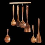 Wooden cooking utensils set with spatula, soup ladle, and rice scoop on a kitchen counter