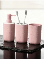 Angled view of pink ceramic set on a modern vanity with green plants.