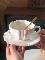 Pink cherry blossom mug with saucer on a dining table