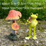 Close-up of frog faces on seesaw, one smiling, one winking, in a garden setting with small mushrooms.