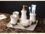 Set of bathroom accessories arranged on a white vanity, highlighting their white porcelain finish.