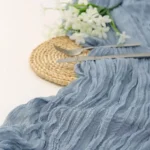 Rustic cheesecloth table runner on wooden table with boho decor