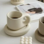 Elegant ceramic cup and saucer set with floral design on a wooden table