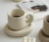 Elegant ceramic cup and saucer set with floral design on a wooden table