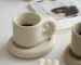 Elegant ceramic cup and saucer set with floral design on a wooden table