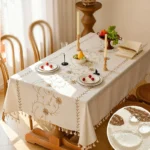 Nordic linen waterproof table protector on dining table with embroidered edges