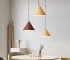 Modern wood pendant light hanging over a dining table in a cozy living room
