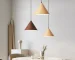 Modern wood pendant light hanging over a dining table in a cozy living room