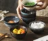 Set of four Japanese rice bowls in assorted colors on a wooden table