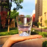 Transparent snow mountain whiskey glasses with Mount Fuji shape on a wooden table