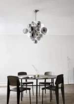 Smoky gray chandelier with glass bubbles hanging over a modern dining table