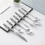 Stainless steel flatware set with ceramic pearl handles on wooden table