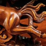 Resin horse statue in center of wine cabinet, surrounded by wine bottles and glasses, office setting.