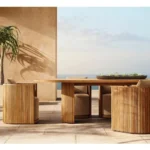 French retro oval dining table with natural wood top and teak base in a dining room setting
