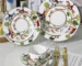 Ceramic dinner plates arranged on a wooden table with cutlery and napkins