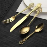 24-piece stainless steel cutlery set with gold handles displayed on a wooden table