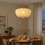 Wabi sabi pendant light hanging over a wooden dining table in a cozy room