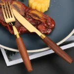 4-piece stainless steel flatware set with sapele wooden handles on a table