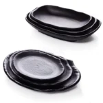 Black melamine dinner plates stacked elegantly on a wooden table