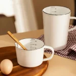 Enamel baking measuring cup with dual scale markings on a kitchen counter