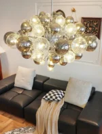 Smoky gray chandelier with glass bubbles hanging over a modern dining table