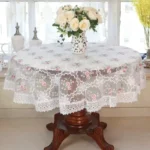 Elegant lace tablecloth with rose gold embroidery on a dining table