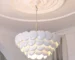Modern ceramic chandelier hanging in a stylish living room with warm LED light