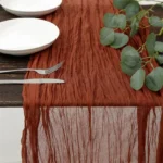 Rustic cheesecloth table runner on wooden table with boho decor