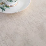 Round linen tablecloth with tassels on a dining table