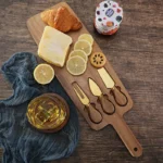 Acacia cheese board set with cheese knives and wooden cutting board on a table