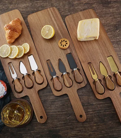 Acacia cheese board set with cheese knives and wooden cutting board on a table