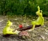 Fairy garden frog couple on a wooden seesaw in a miniature garden setting