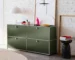 Olive green storage cabinet with metal frame and drawers in a modern living room