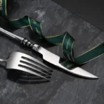 Elegant French stainless steel cutlery set with pointed tail handles on a wooden table