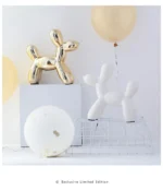 Ceramic gold dog on a side table with a lamp and remote.