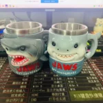 Jaws 50th Anniversary 3D shark mug on a wooden table with coffee